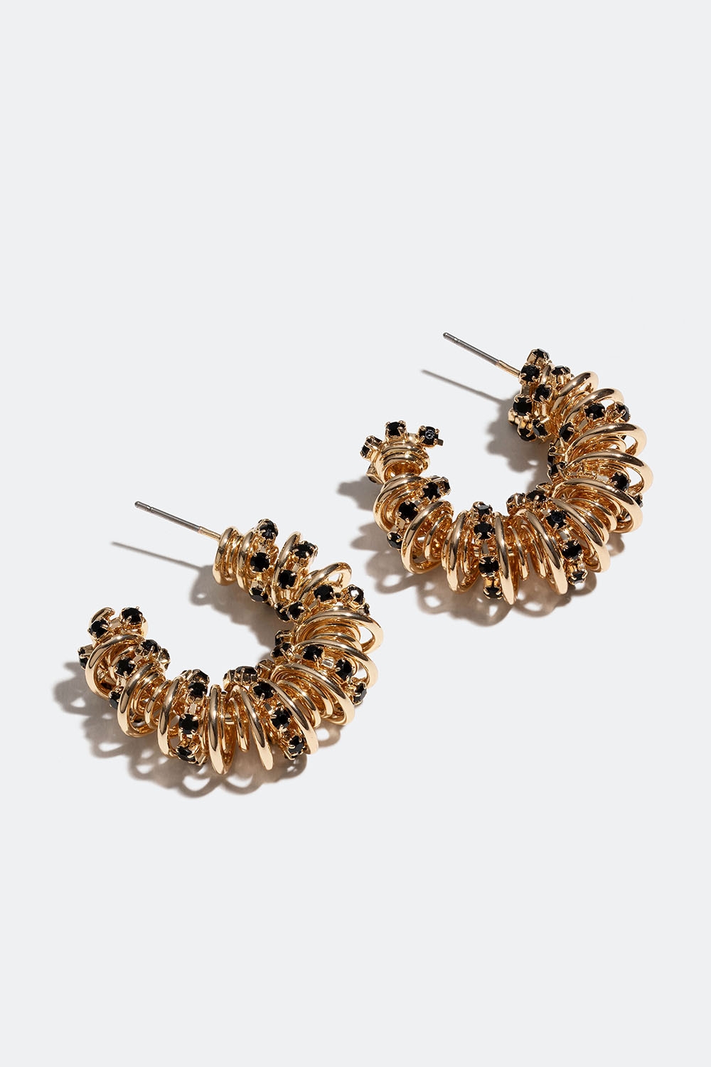 Chunky guldfärgade hoops med tvinnad design och svarta glasstenar i gruppen Smycken / Örhängen / Hoops hos Glitter (253006372002)