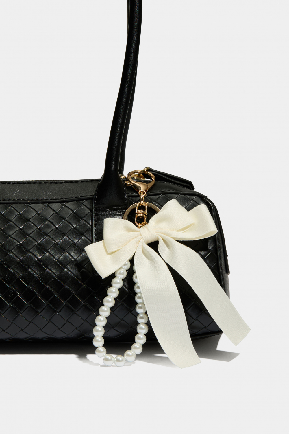 Väskdekoration med vit rosett och pärlband