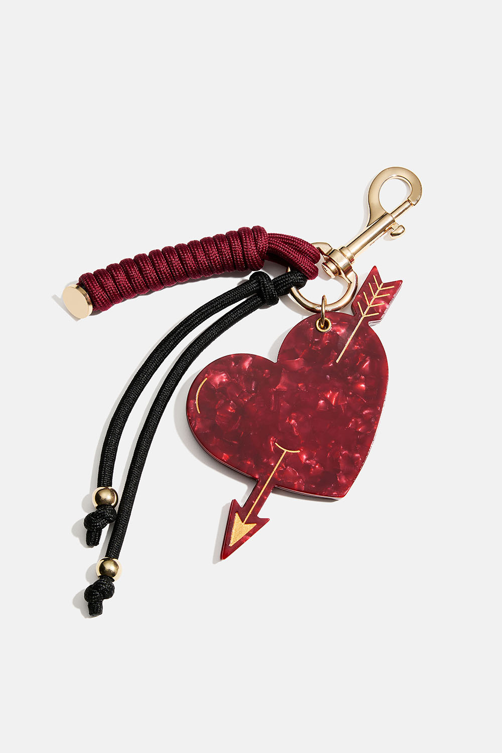 Väskdekoration med liten spegel, hjärta och snören.