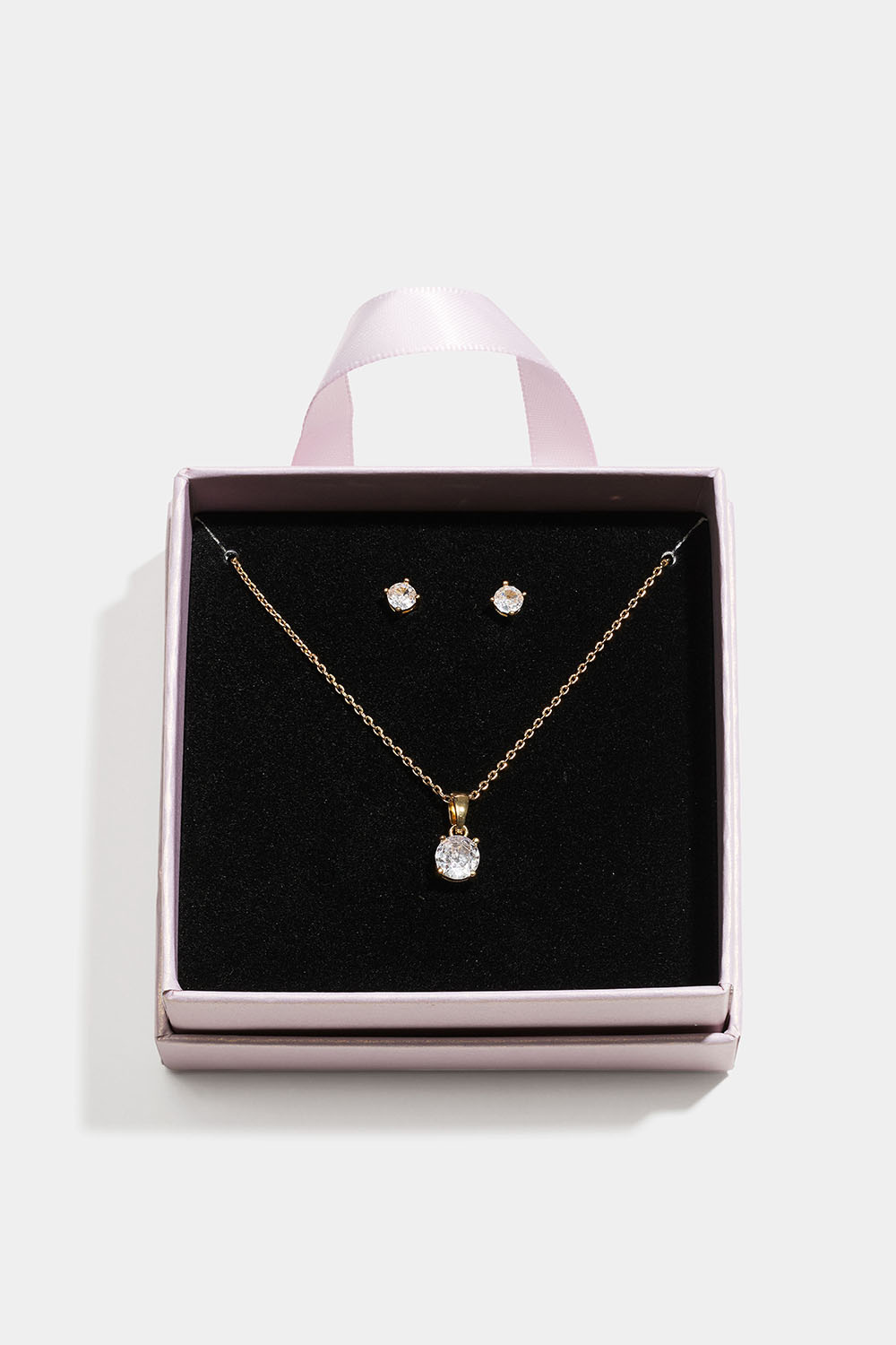 Guldfärgat smyckesset med glasstenar i presentask