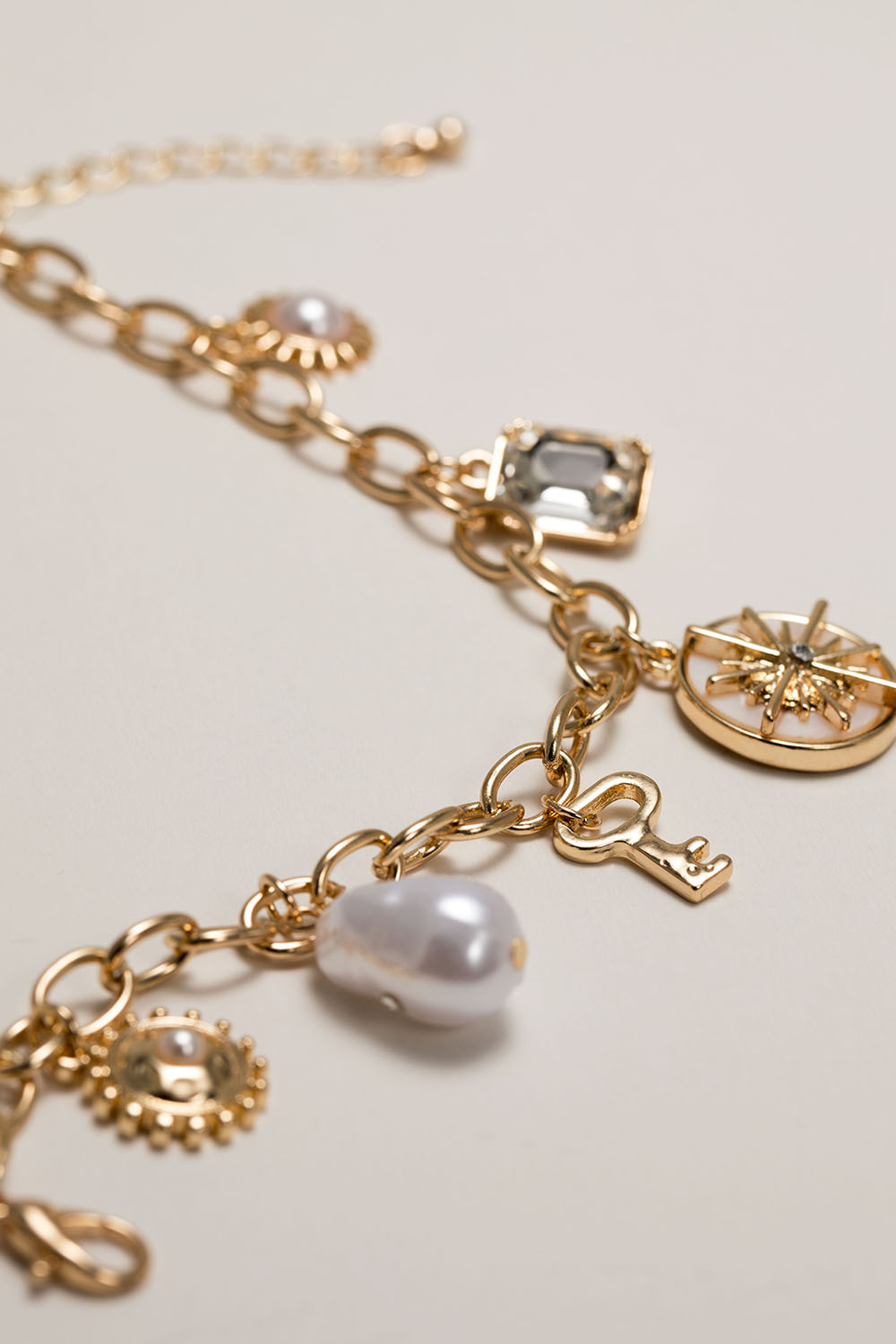 Guldfärgad armband med berlocker