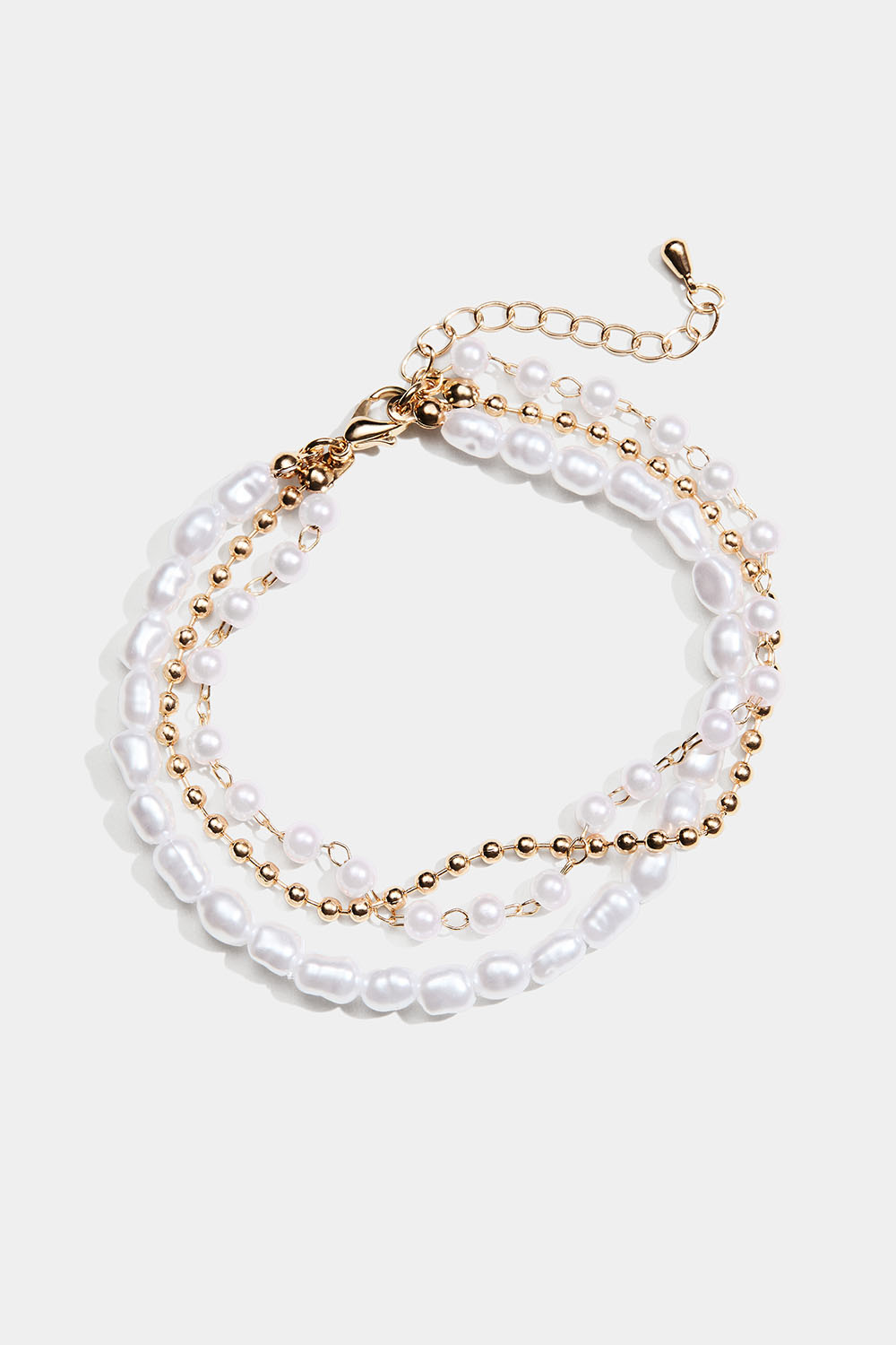Guldfärgat trippelarmband med vita pärlor