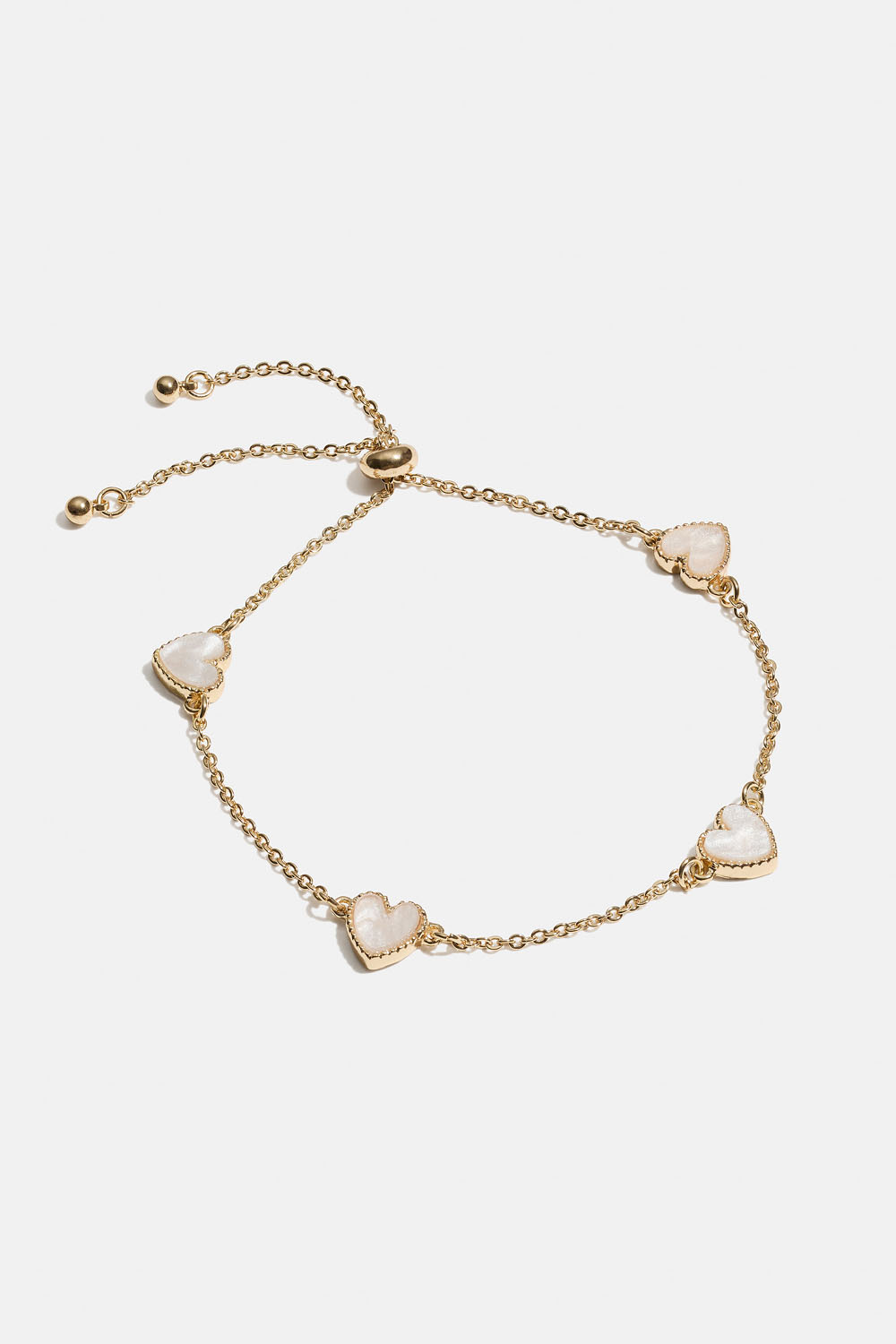 Guldfärgat armband med vita hjärtan