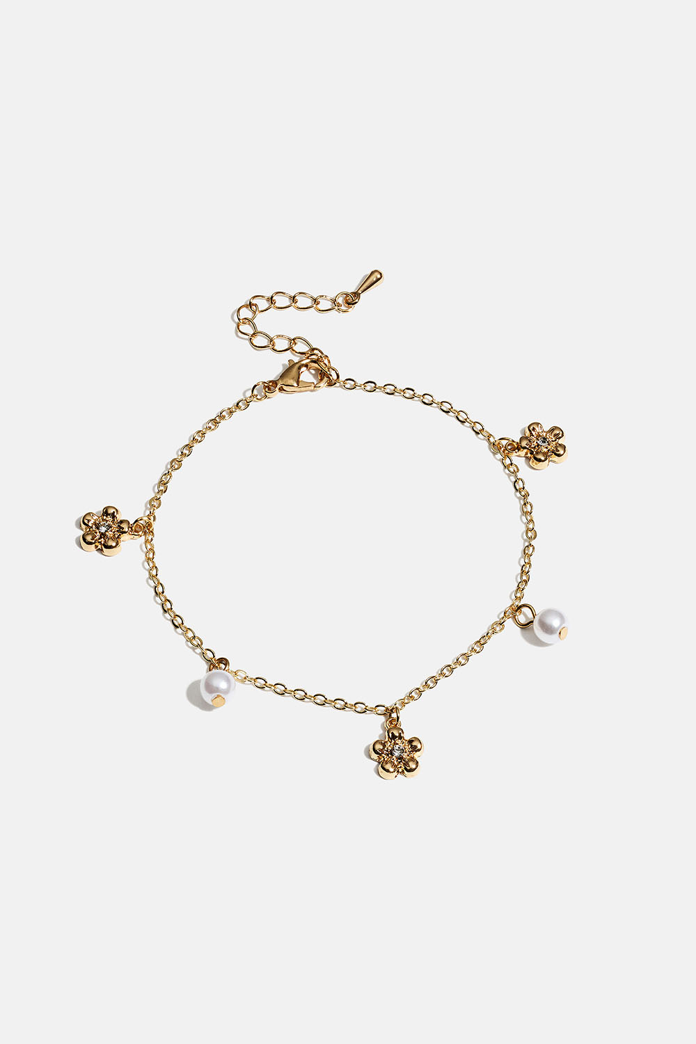Guldfärgat armband med blommor och vita pärlor
