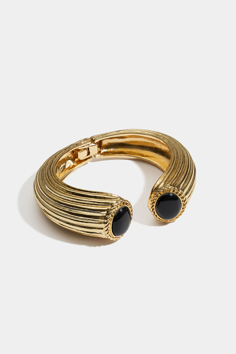 Guldfärgat strukturerad bangle med svarta stenar