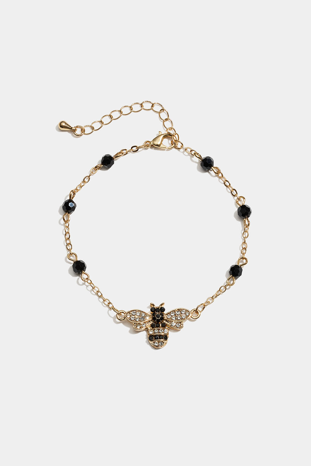Guldfärgat armband med bi-berlock och svarta glasstenar