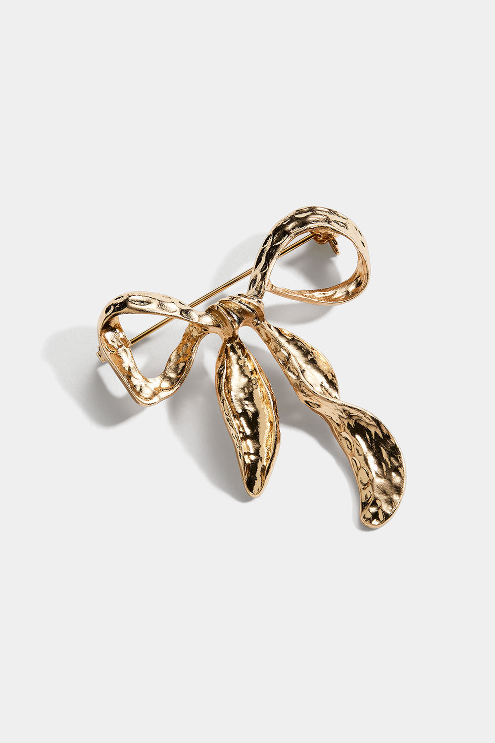 Guldfärgad brosch med hamrad rosett