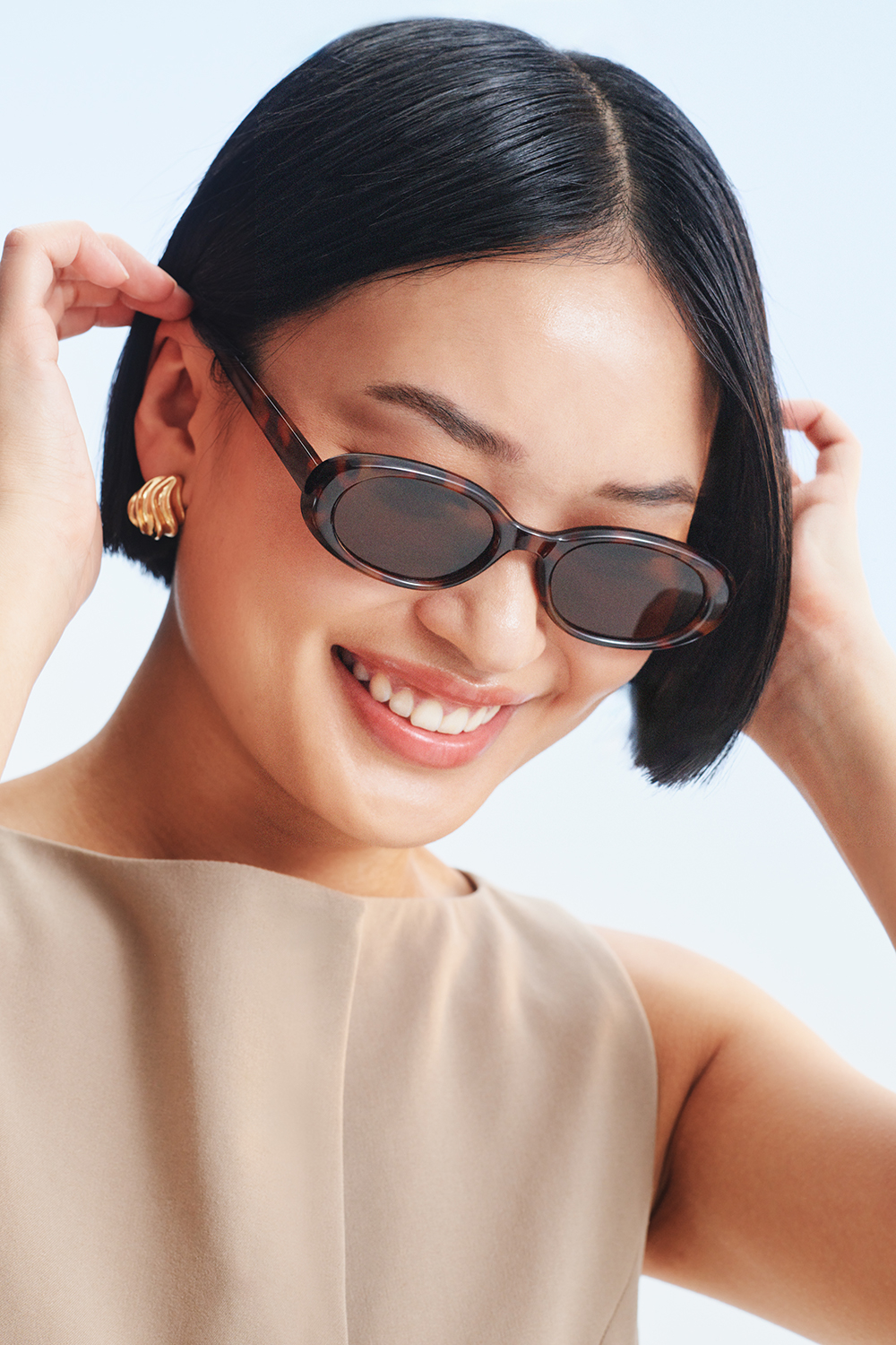 Guldfärgade örhängen i vågig droppform