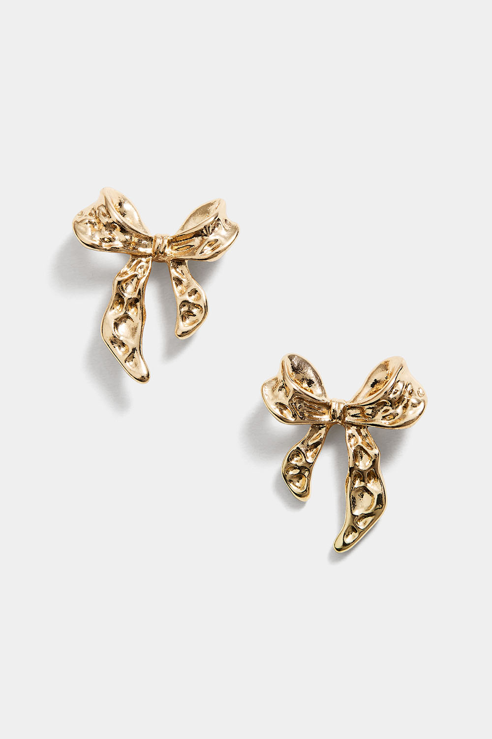 Guldfärgade studs med hamrade rosetter