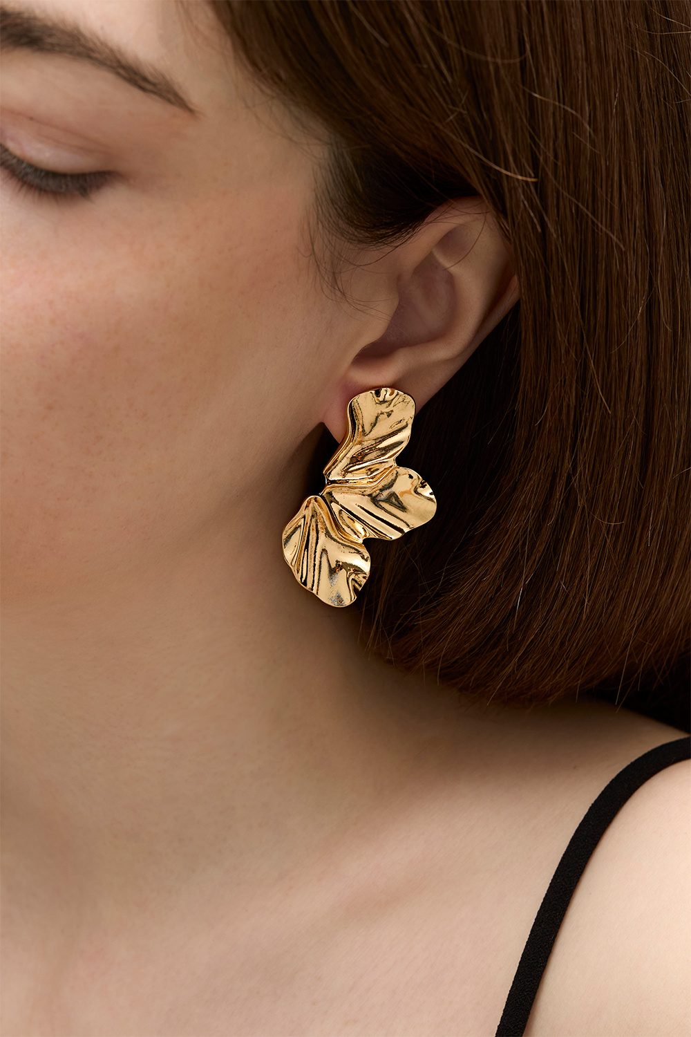 Guldfärgade örhängen med blomblad