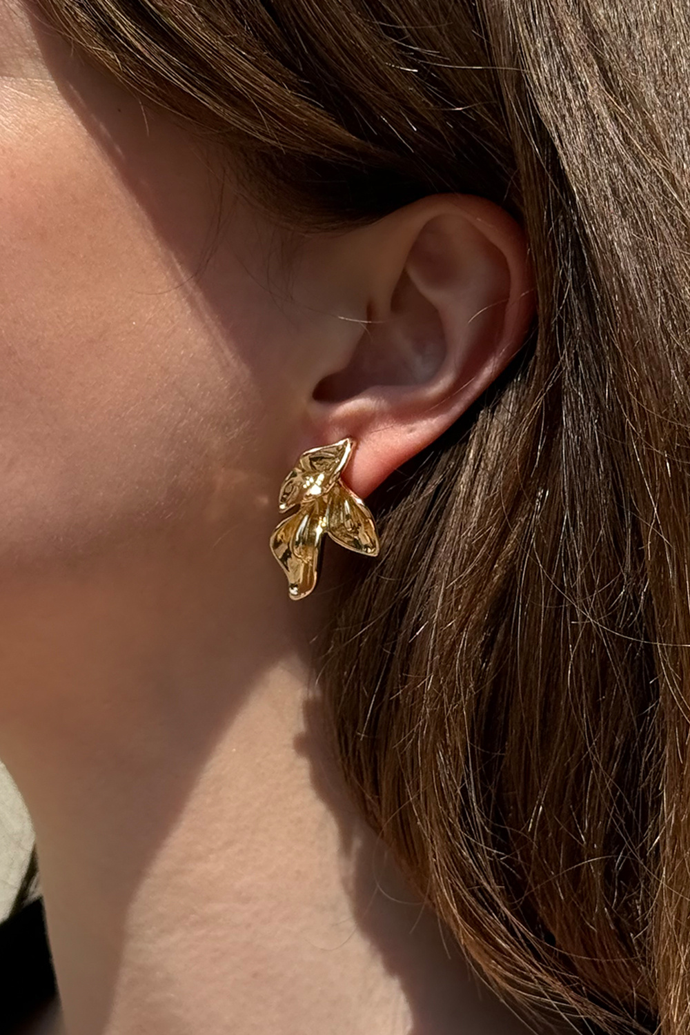 Guldfärgade örhängen med bladformer