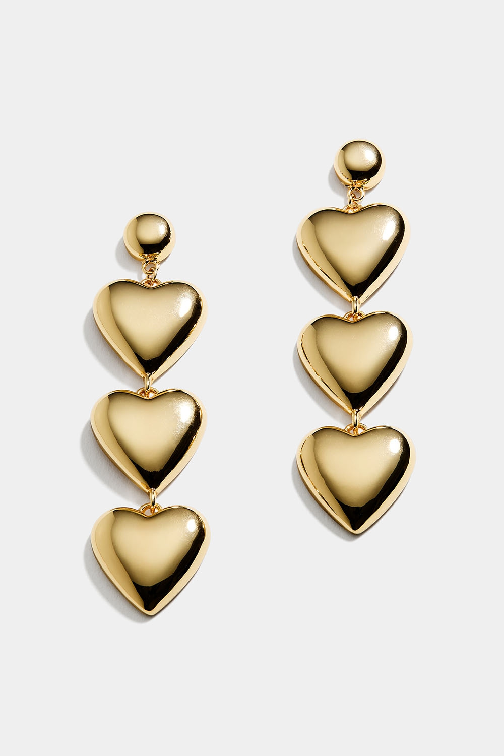 Guldfärgade långa örhängen med tre hjärtan