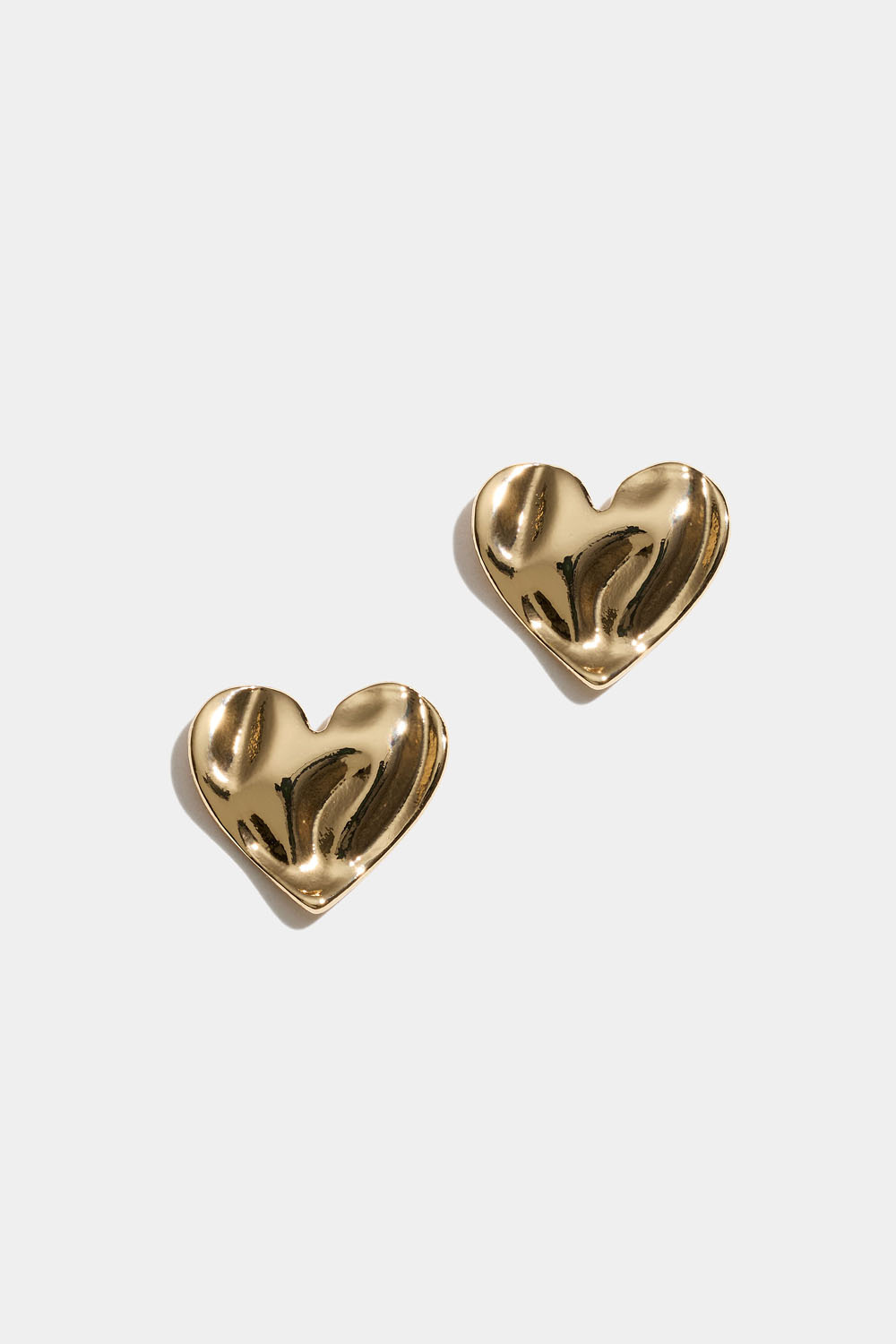 Guldfärgade hjärtstuds med organisk textur