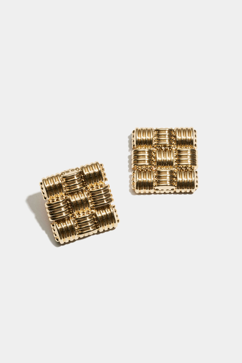 Stora guldfärgade studs med flätad textur