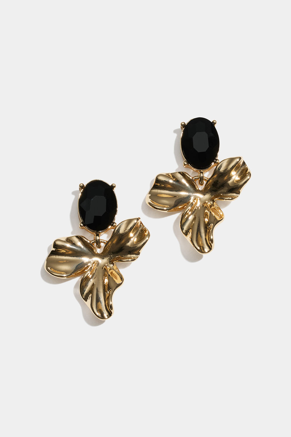Guldfärgade örhängen med blad och svart glassten