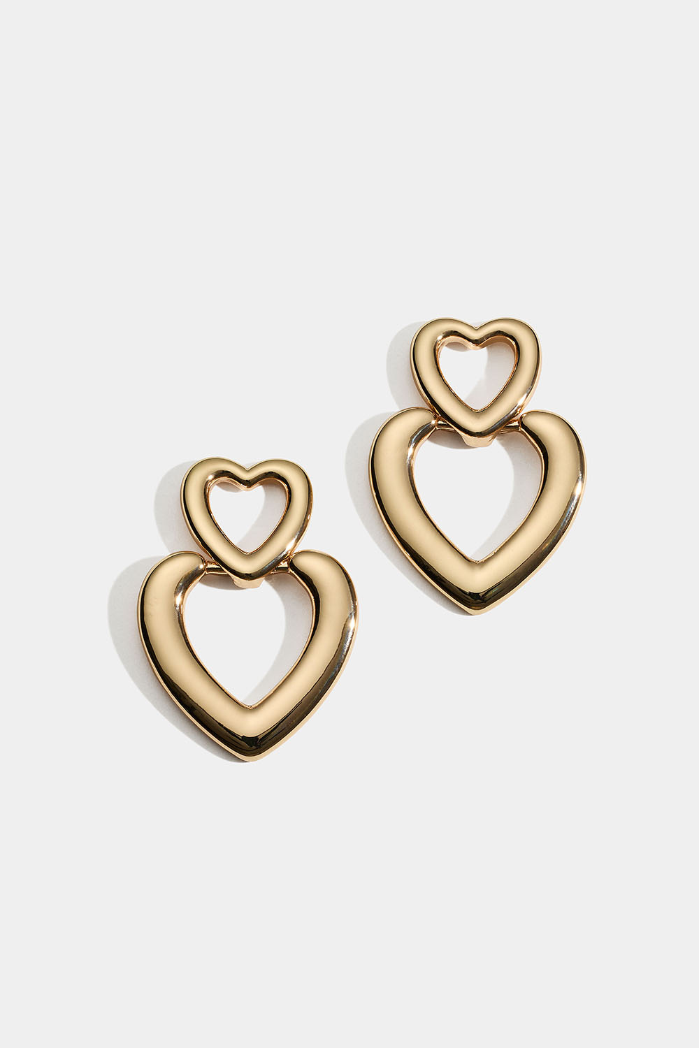 Guldfärgade örhängen med två hjärtan
