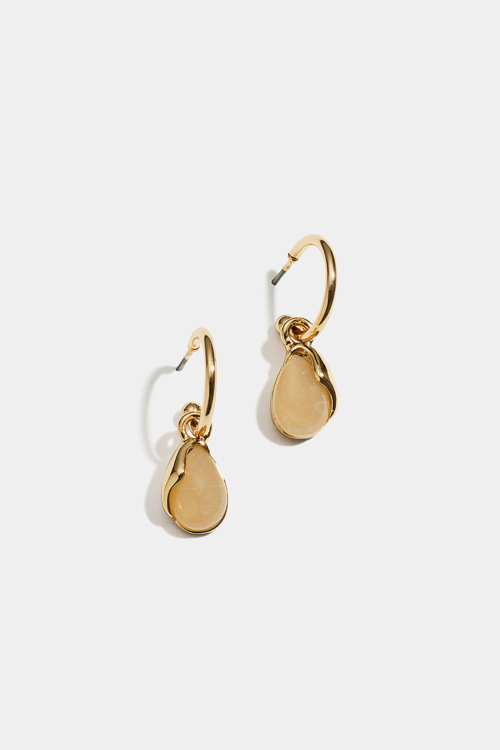Guldfärgade hoops med beige resinberlock