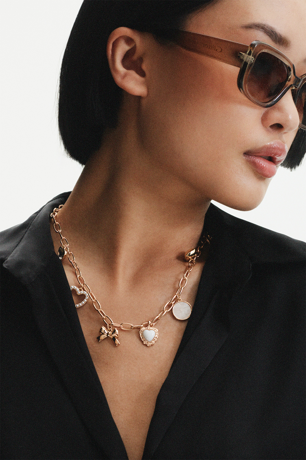 Guldfärgad halskedja med berlocker