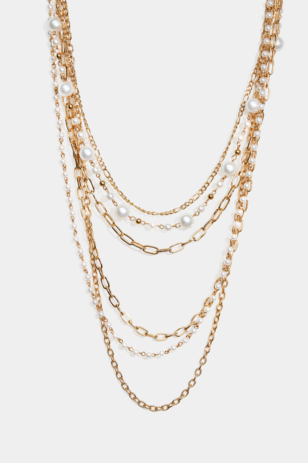 Guldfärgat långt halsband med pärlor och olika kedjor