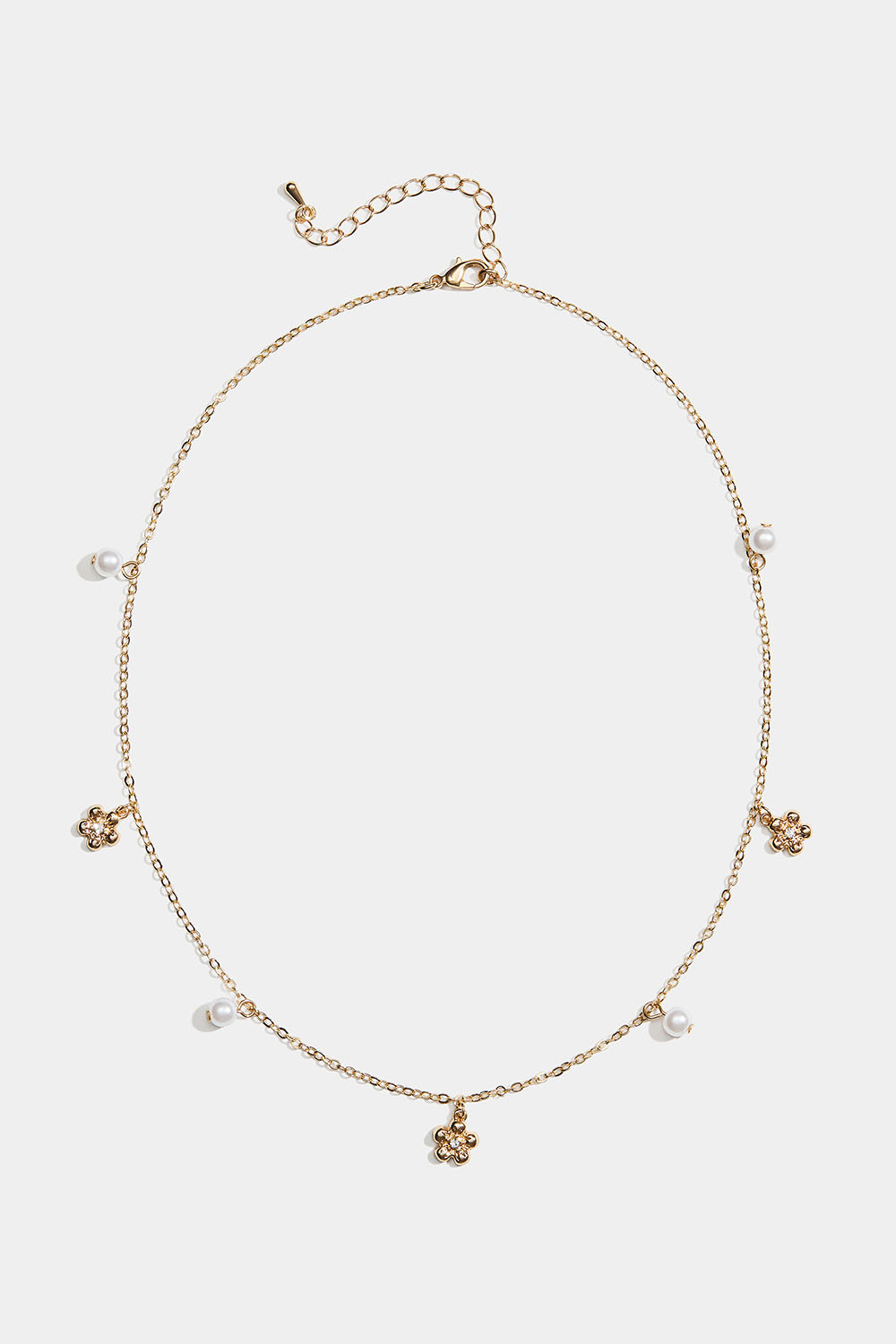 Guldfärgat halsband med blommor och vita pärlor