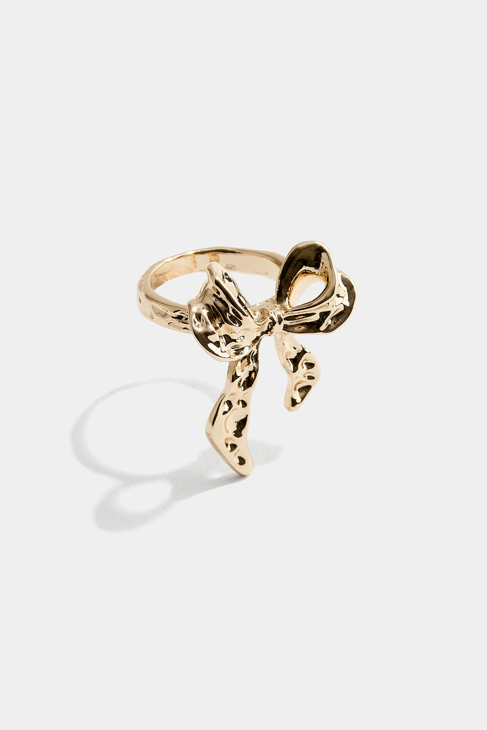 Guldfärgad ring med hamrad rosett