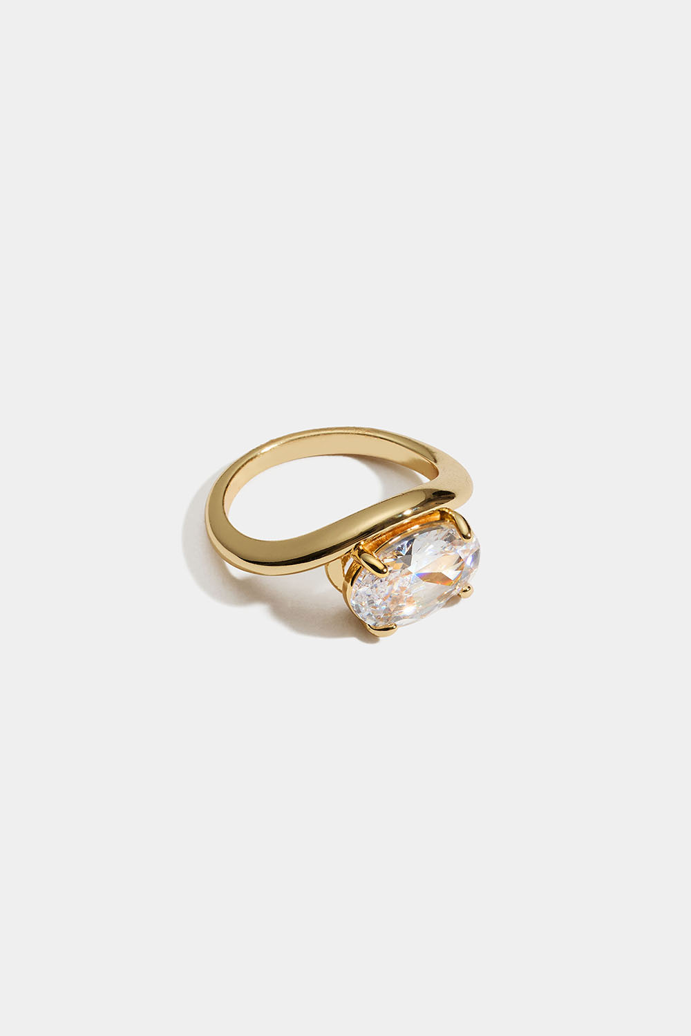 Guldfärgad ring i vågig design med oval glassten
