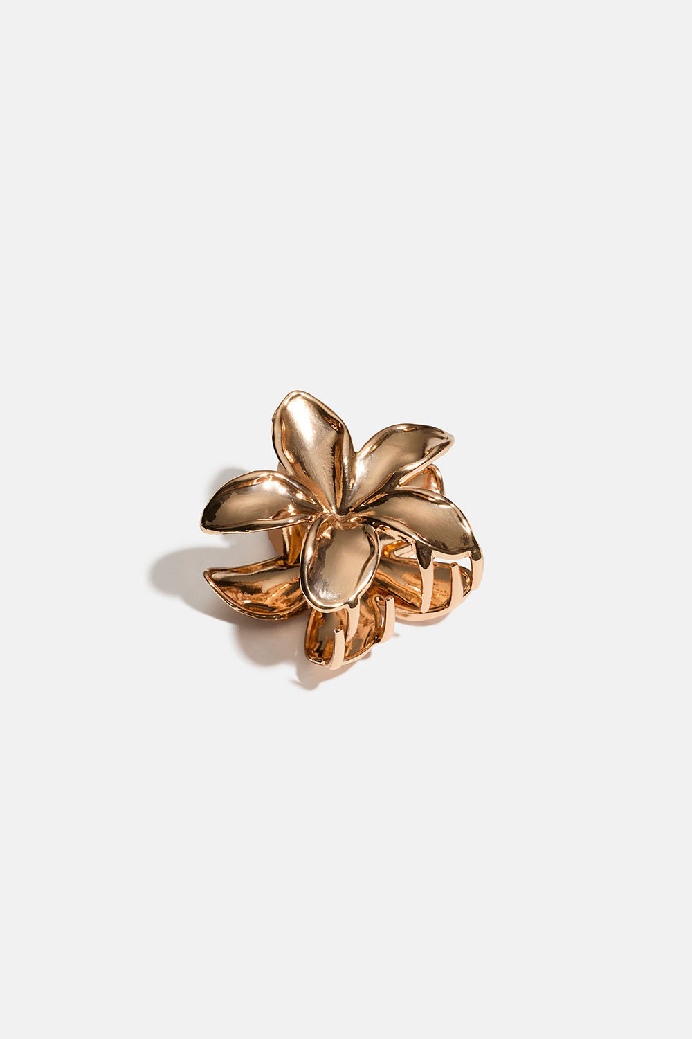 Liten blomformad hårklämma i guldfärgad metall